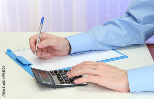 Photo: Closeup of businessman hands with calculator Closeup of businessman hands with calculator