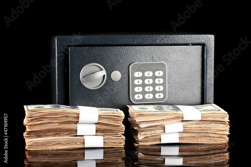 Photo: American dollars and safe isolated on black American dollars and safe isolated on black