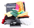 Open silver suitcase with clothing isolated on white