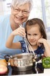 Granny and granddaughter cooking smiling