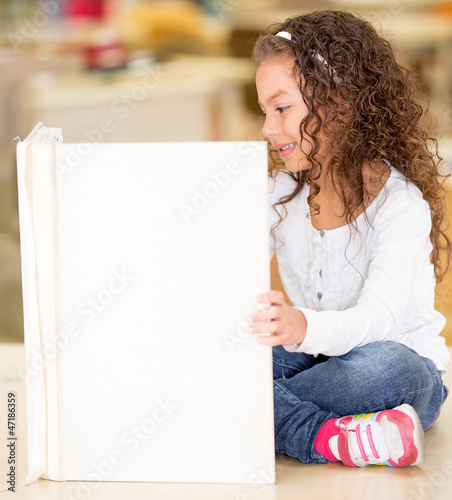 Photo: Little girl reading a book Little girl reading a book