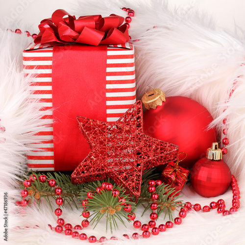 Photo: Christmas gift and red christmas balls in white fur Christmas gift and red christmas balls in white fur