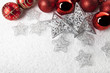 rote Baumkugeln und silberne Sterne im Schnee