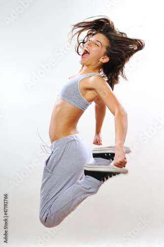 Photo: powerful girl jumping and exercising in studio powerful girl jumping and exercising in studio