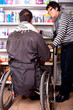 Rollstuhlfahrer beim shoppen mit Hilfe