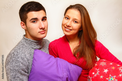Photo: Smiling boy and girl with Christmas pillows isolated on white ba Smiling boy and girl with Christmas pillows isolated on white ba