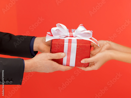 Photo: man and woman's hands with gift box man and woman's hands with gift box