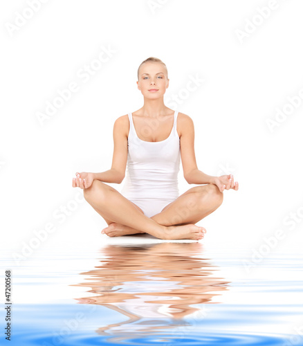 Photo: woman practicing lotus pose on white sand woman practicing lotus pose on white sand