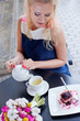 a beautiful young blond girl in summer dress at the table in pav