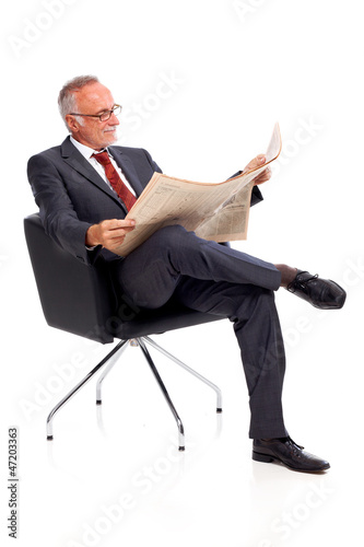 Photo: Senior business man reading newspaper Senior business man reading newspaper