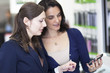 Shop assistant helping a customer choosing a smart phone