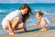 Mother playing with daughter on the beach