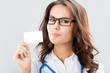 Young female doctor showing blank business card