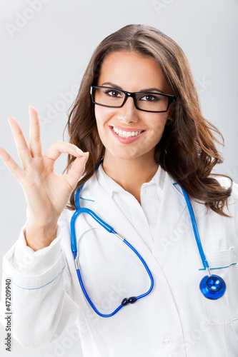 Photo: Doctor showing okay gesture, over grey Doctor showing okay gesture, over grey