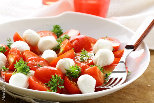 Photo: Italian Caprese salad with cherry tomatoes and baby mozzarella Italian Caprese salad with cherry tomatoes and baby mozzarella
