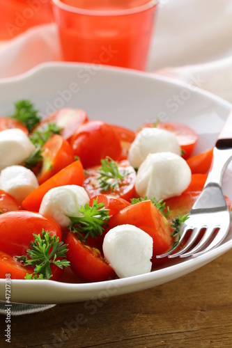 Photo: Italian Caprese salad with cherry tomatoes and baby mozzarella Italian Caprese salad with cherry tomatoes and baby mozzarella