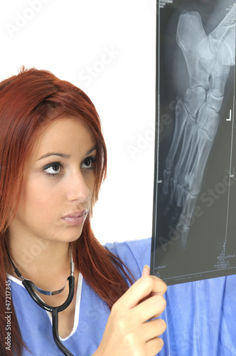Photo: Young doctor looking at X-ray on a white background Young doctor looking at X-ray on a white background