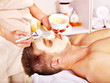 Clay facial mask in beauty spa.