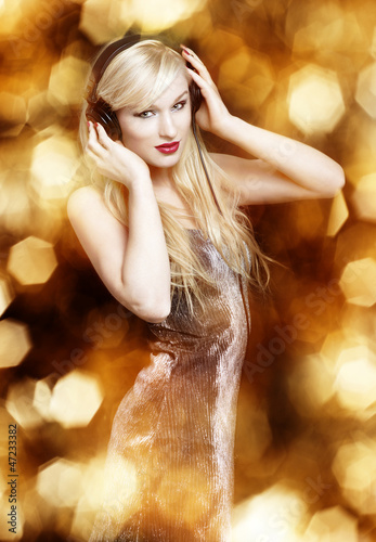 Photo: Sexy blond woman on golden background Sexy blond woman on golden background