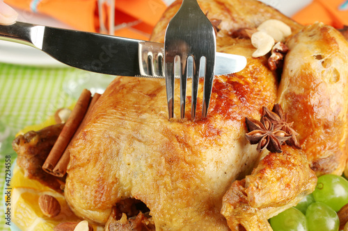 Photo: Cutting baked chicken close-up. Thanksgiving Day Cutting baked chicken close-up. Thanksgiving Day