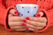 hands holding mug of hot drink, close-up
