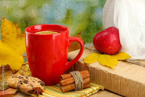 Photo: cup of hot tea and autumn leaves, on rain background cup of hot tea and autumn leaves, on rain background