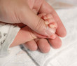 newborn baby hand on a male hand