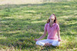 Photo: yoga woman on green grass in lotus pose yoga woman on green grass in lotus pose