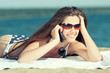woman talking by phone on a beach