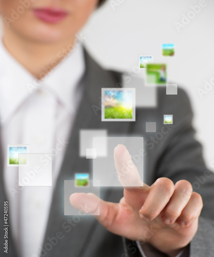 Photo: Young business woman pushing a button on a virtual touch screen Young business woman pushing a button on a virtual touch screen
