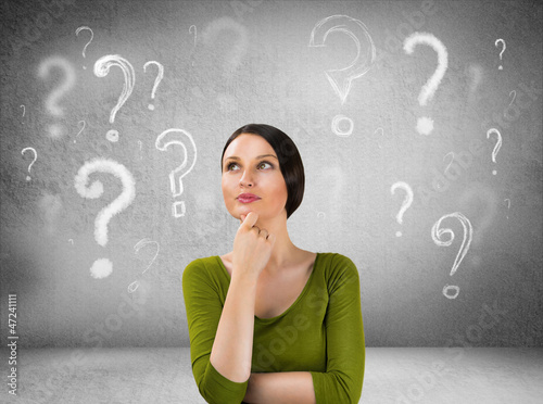 Photo: Beautiful woman with questioning expression and question marks a Beautiful woman with questioning expression and question marks a