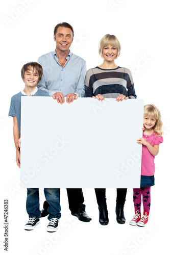 Photo: Active young family displaying blank ad board Active young family displaying blank ad board