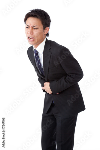 Photo: young businessman suffering from abdominal pain young businessman suffering from abdominal pain