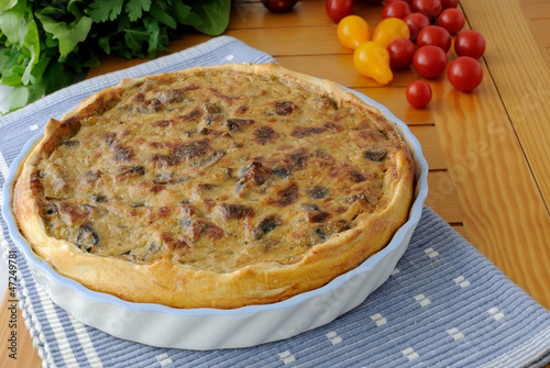 Photo: Tart with mushrooms in a ceramic form on a napkin Tart with mushrooms in a ceramic form on a napkin