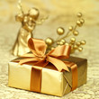 Christmas gift wrapped in golden paper with an angel