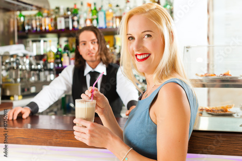 Photo: Barista with client in his cafe or coffeeshop Barista with client in his cafe or coffeeshop