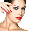 Beautiful woman with red nails and fashion makeup