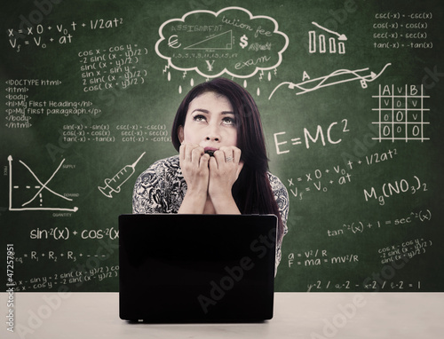 Photo: Girl with laptop is nervous facing exam Girl with laptop is nervous facing exam