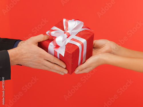 Photo: man and woman's hands with gift box man and woman's hands with gift box