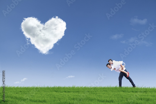 Photo: Guy giving girl piggyback ride in field on Valentine's day Guy giving girl piggyback ride in field on Valentine's day