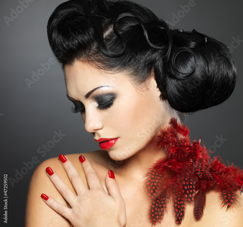 Photo: Woman with red nails and creative hairstyle Woman with red nails and creative hairstyle