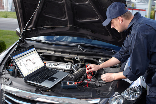 Photo: Car mechanic working in auto repair service. Car mechanic working in auto repair service.