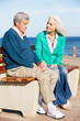 Senior Woman Comforting Depressed Husband Sitting On Bench
