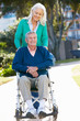 Senior Woman Pushing Husband In Wheelchair