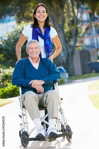 Photo: Adult Daughter Pushing Senior Father In Wheelchair Adult Daughter Pushing Senior Father In Wheelchair