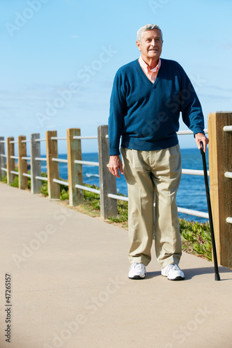Photo: Senior Man Walking Along Path By The Sea Senior Man Walking Along Path By The Sea