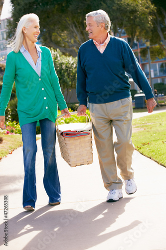 Photo: Senior Couple Walking In Park Together With Picnic Basket Senior Couple Walking In Park Together With Picnic Basket