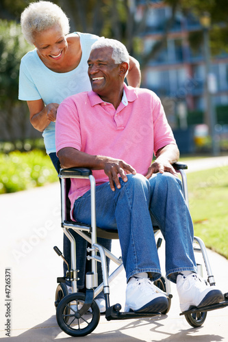 Photo: Senior Woman Pushing Husband In Wheelchair Senior Woman Pushing Husband In Wheelchair