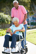 Senior Woman Pushing Unhappy Husband In Wheelchair