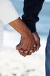 Close Up Of Senior Couple Holding Hands On Beach